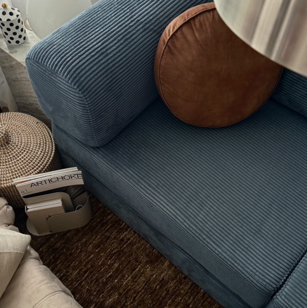 Blue corduroy Nova modular sofa bed with a brown bolster cushion